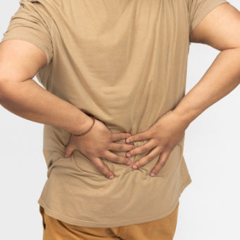 Man grabs lower back in pain